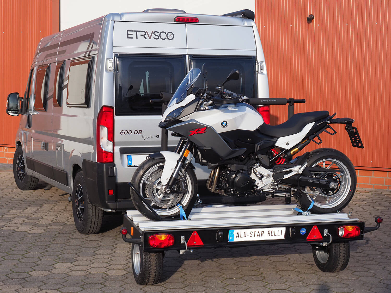 SMV Alu-Star Rolli beladen mit einem Motorrad hinter einem Camper.