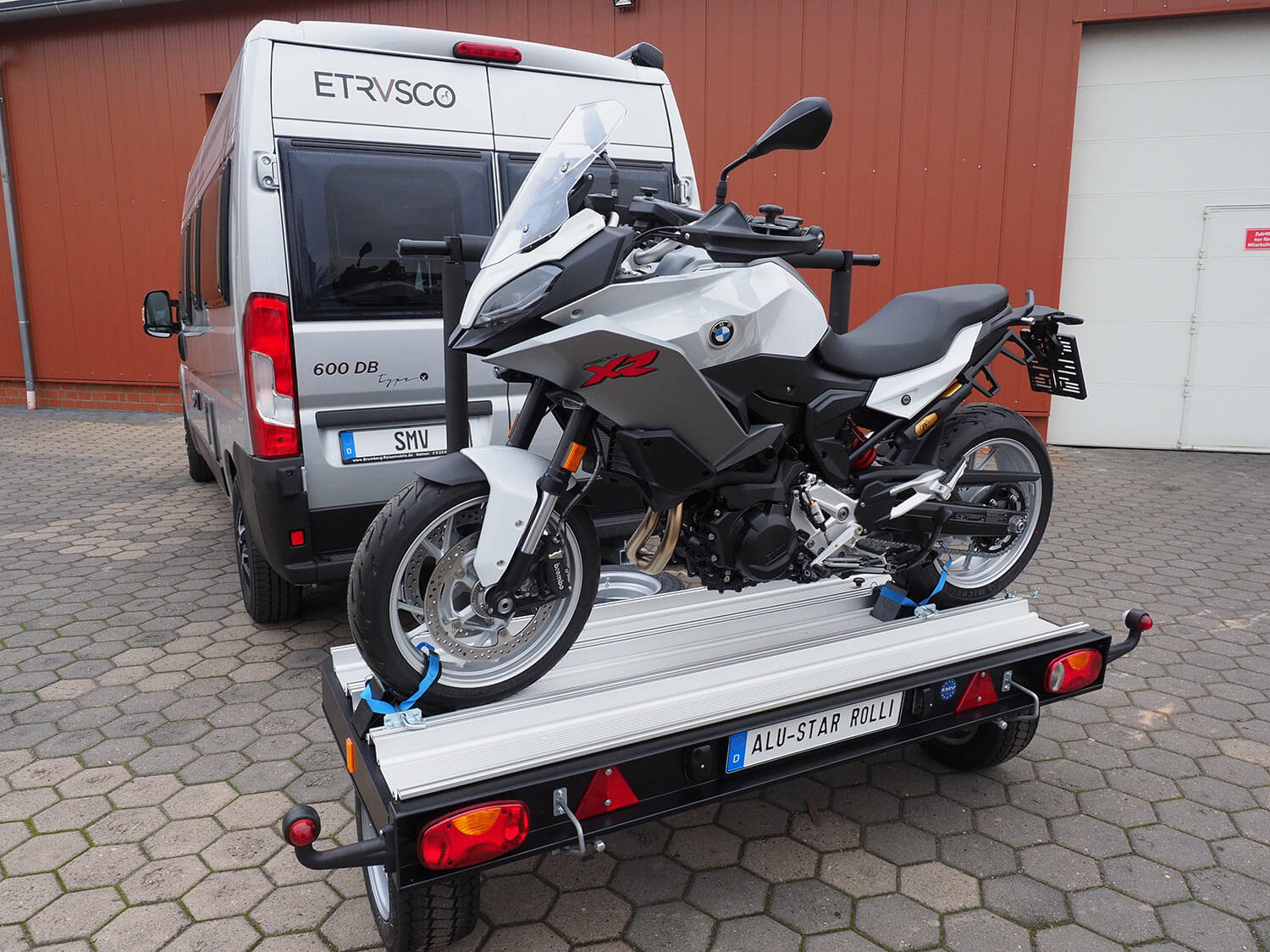 SMV Alu-Star Rolli beladen mit einem Motorrad hinter einem Camper.