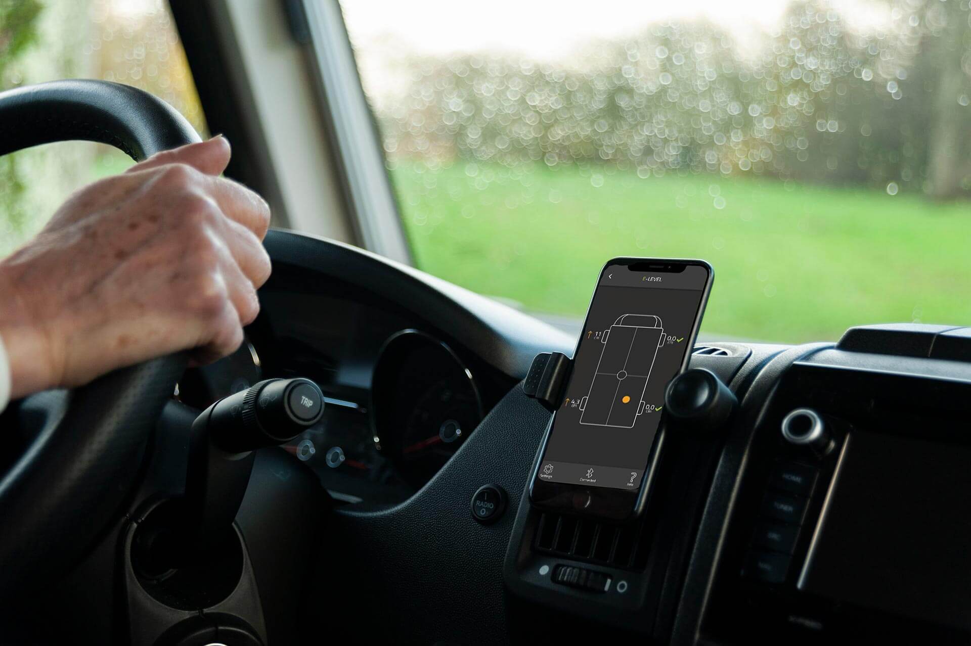 Cockpit eines Wohnmobils mit Smartphone und Check des Levels im Innenraum.