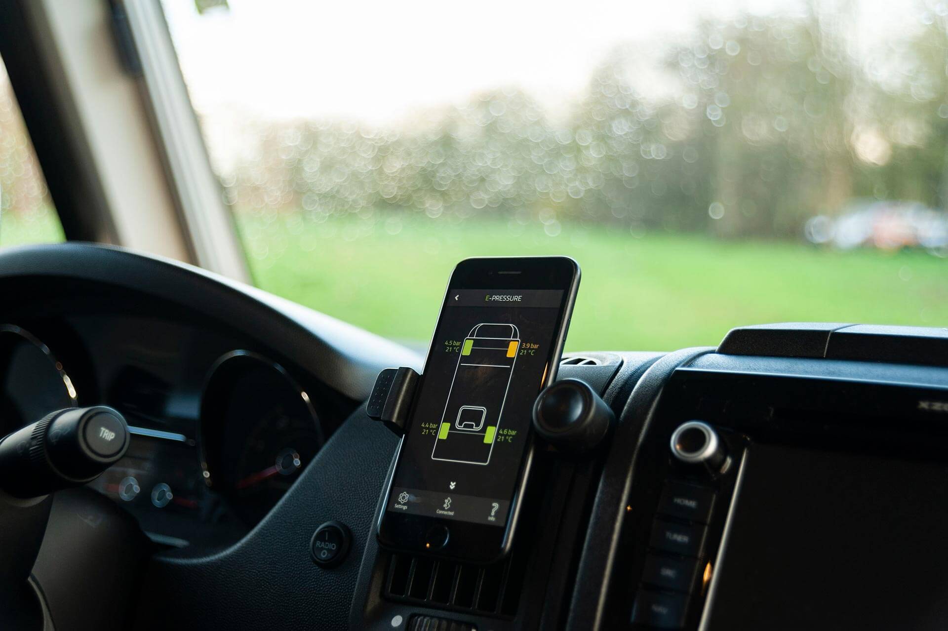 Smartphone im Cockpit eines Wohnmobils zeigt E-Pressure Warnmeldung.