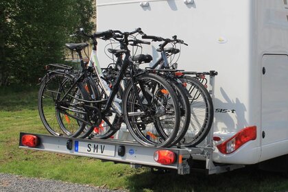 Vier Fahrräder auf SMV Rad-Max-Bike exklusiv am Heck eines Wohnmobils.