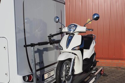 Seitenansicht SMV Rad Max 130 mit einem Roller beladen am Wohnmobilheck.