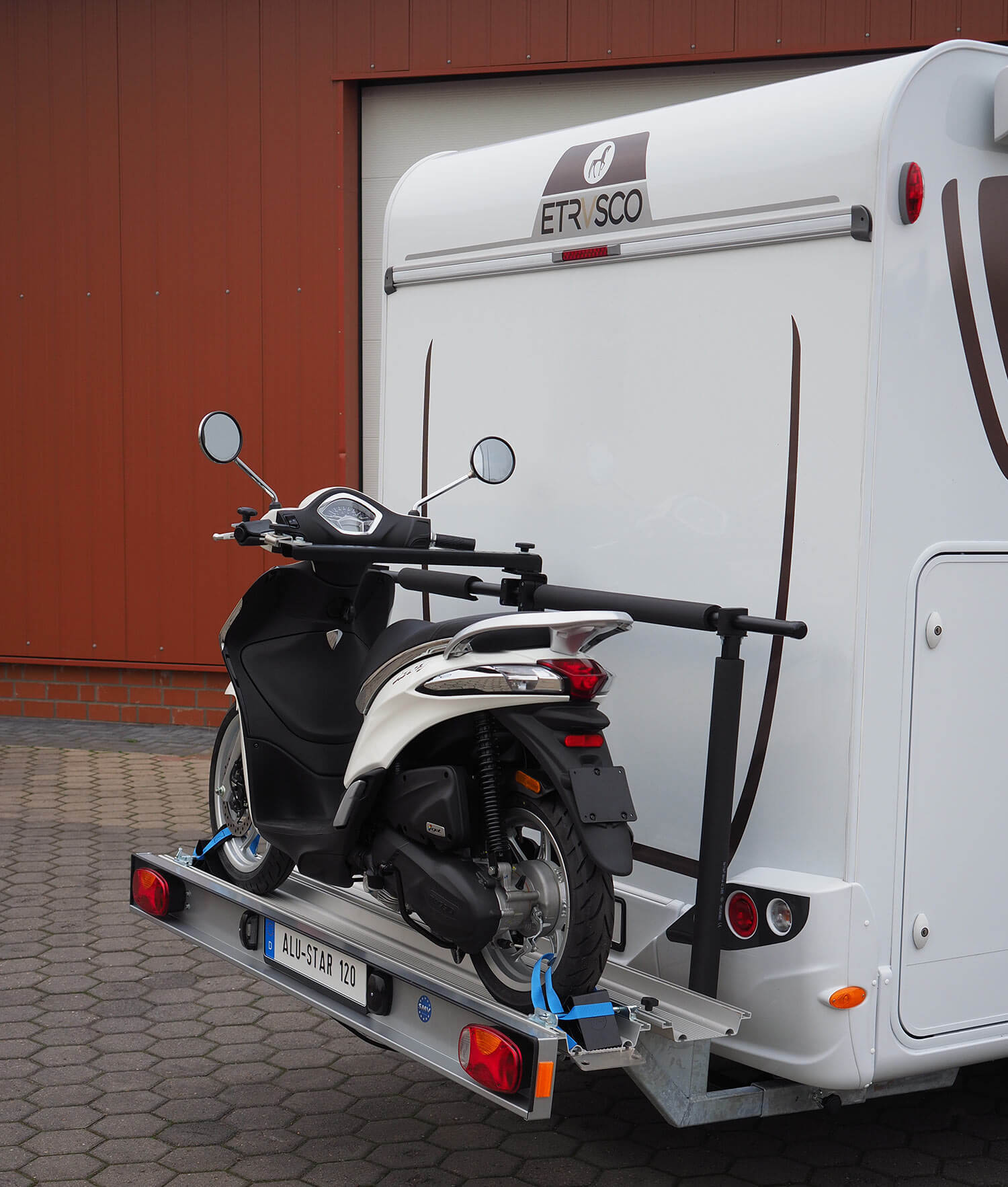 SMV Alu-Star 120 mit beladenem und fixiertem Roller. Heckansicht Wohnmobil.