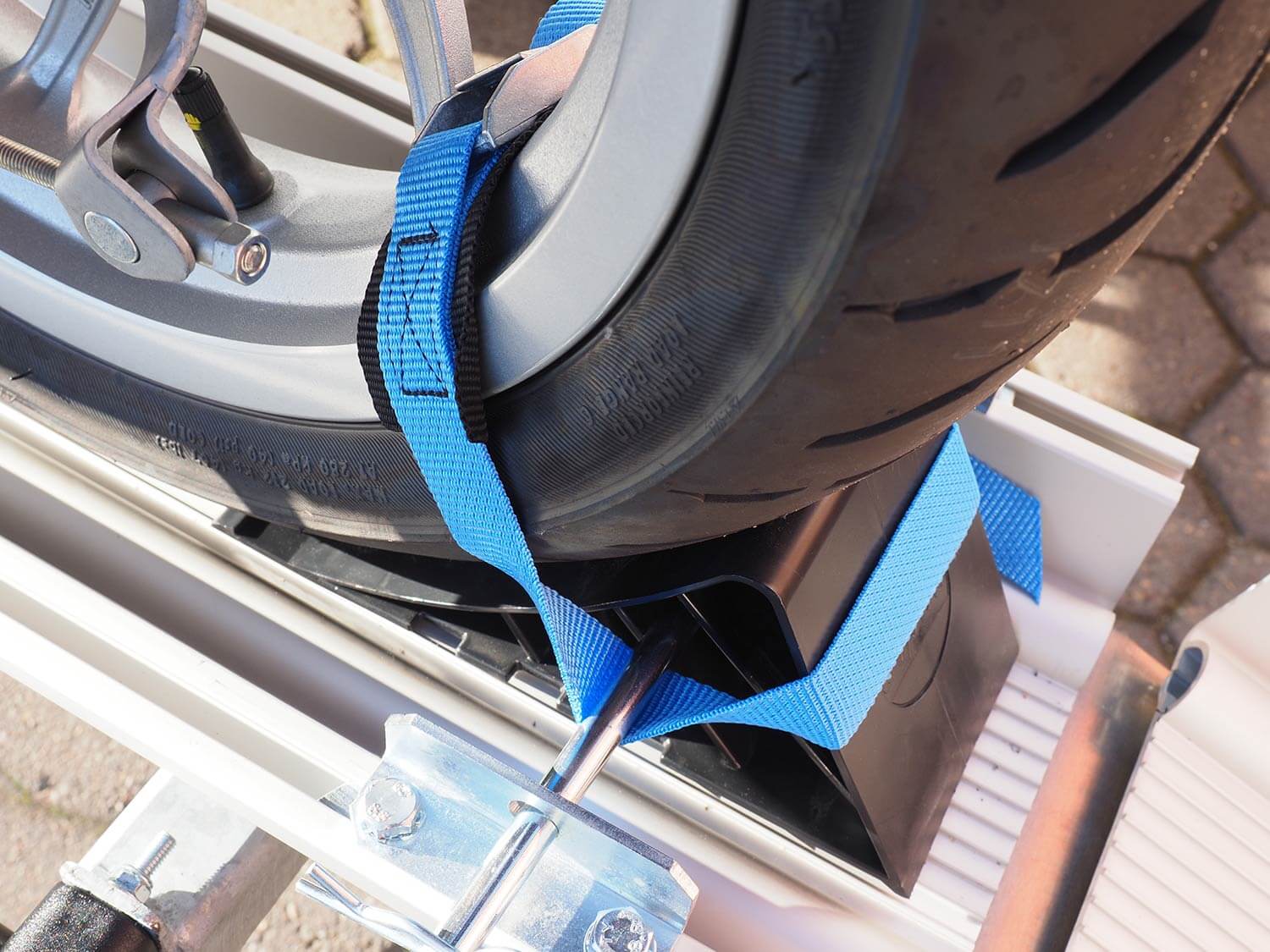 Detailansicht SMV Rad Max 130 mit Kunststoffkeil und Halteriemen am Rad eines Rollers.