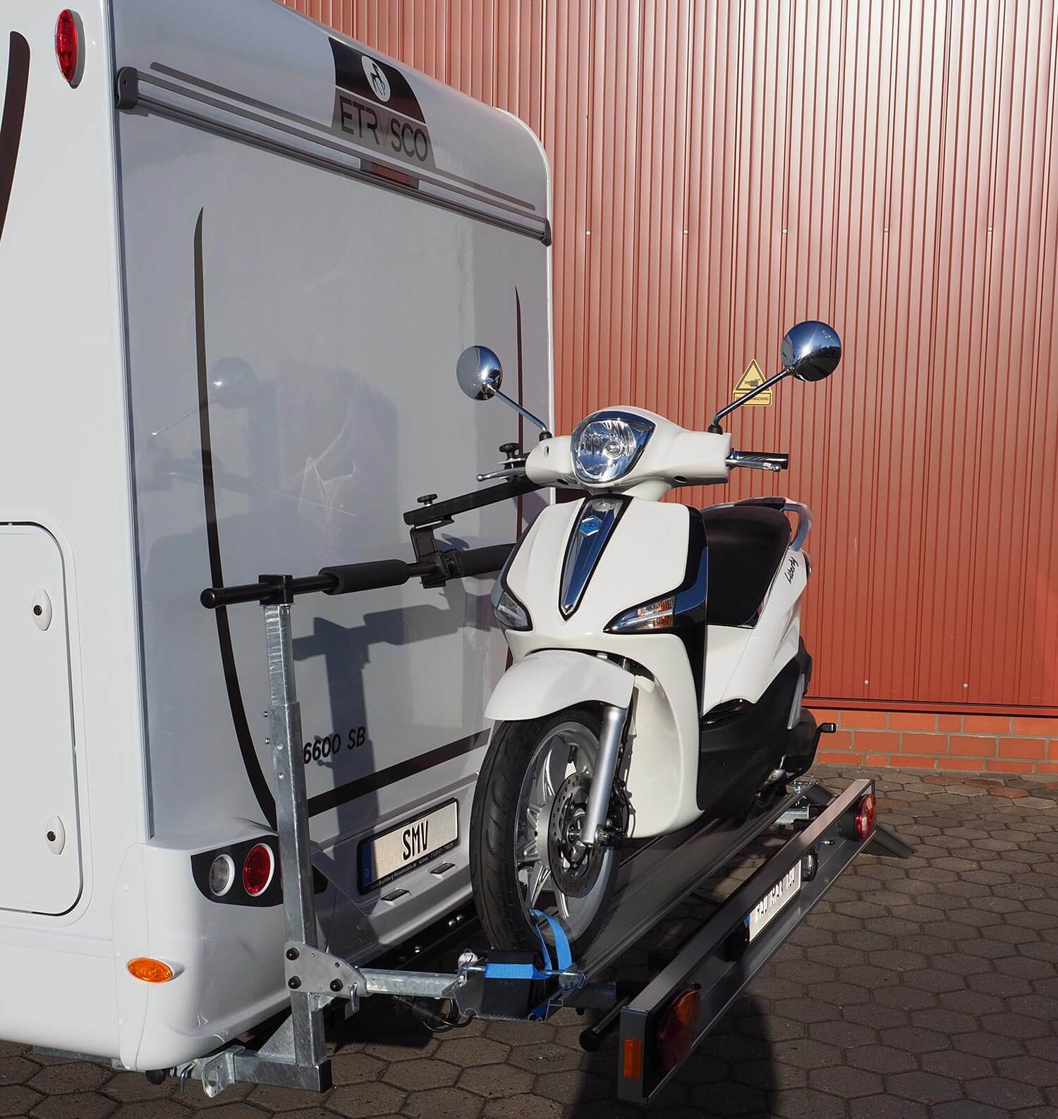 Seitenansicht SMV Rad Max 130 mit einem Roller beladen am Wohnmobilheck.